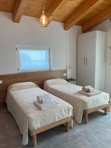 a room with two beds and a window at Agriturismo da Natalino in Ceggia