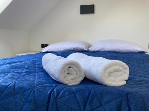 a blue bed with two towels on top of it at Ośrodek Wczasowy Magnat in Łeba