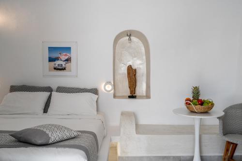 a bedroom with a bed and a table and a chair at Vogue Suites in Oia