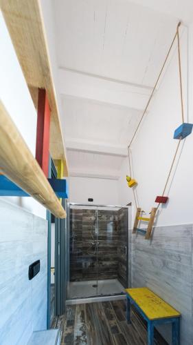 a room with a shower and a yellow bench at La Quercia e l'Asino in Piazza Armerina