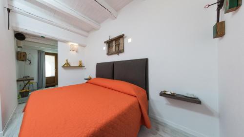 a bedroom with an orange bed in a white room at La Quercia e l'Asino in Piazza Armerina