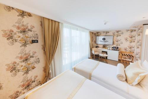 イスタンブールにあるHallmark Hotel & SPA Istanbulのベッド2台とデスクが備わるホテルルームです。
