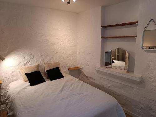 une chambre avec un lit blanc avec un miroir dans l'établissement Cosy appartement intra-muros, à Avignon
