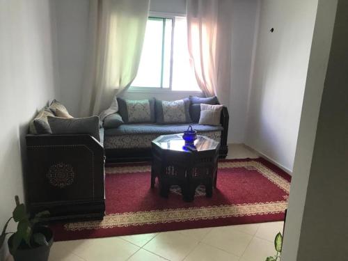 丹吉爾的住宿－Appartement Familial Proche Aeroport Bab Andalous Tanger，客厅配有沙发和桌子
