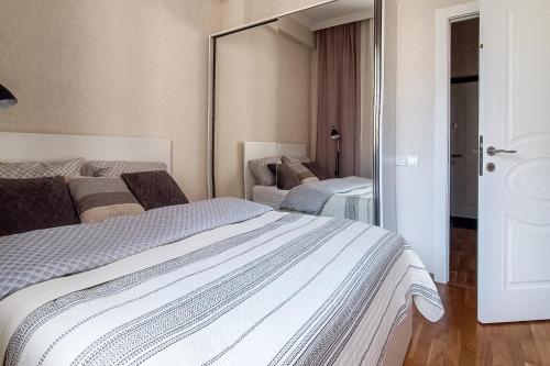 a bedroom with a large bed and a mirror at Стильная квартира в новостройке in Baku