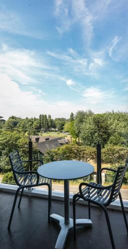 a table and two chairs on a balcony with a view at Thalazur Cabourg - Hôtel & Spa in Cabourg