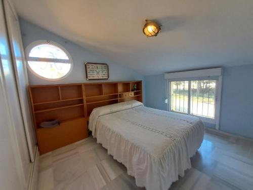 Un dormitorio con una cama y una ventana en Casa playa El Ancla Puerto Santa María, en El Puerto de Santa María