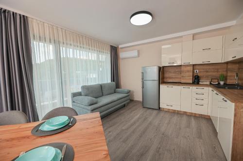 Una cocina y una sala de estar con una mesa y un sofá. en Lux Apartments Kranevo, en Kranevo