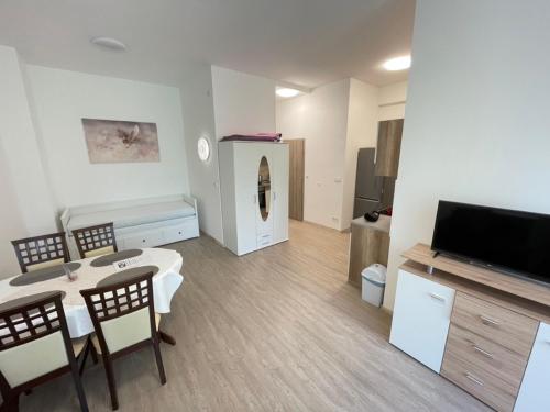 a living room with a table and chairs and a television at Gyöngybagoly Apartman in Balatonberény