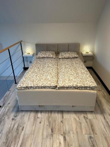 a bedroom with two beds and wooden floors at Domek Apartamenty Sun House in Boszkowo