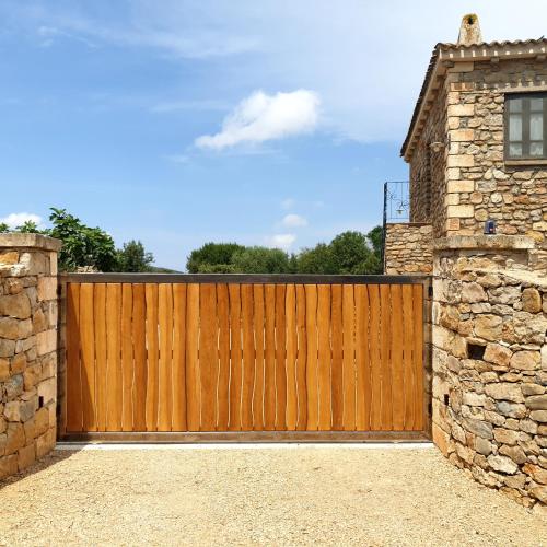 a wooden fence in front of a house at Agriturismo Cuile Querce in Campanedda