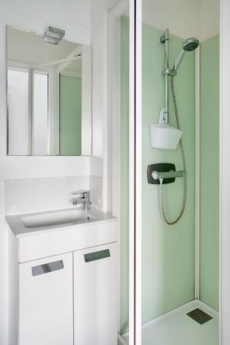 une salle de bain avec un lavabo et une douche dans l'établissement 400m plage de la Cale de Beg Meil, cocon pour 2, à Fouesnant