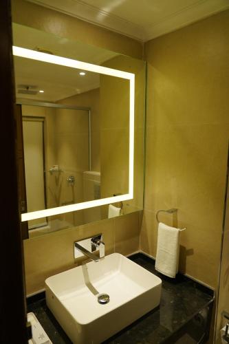 a bathroom with a sink and a large mirror at The Park Regency Hotel in Moga