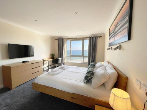 a hotel room with a bed with a large window at Chy Lowen in Newquay