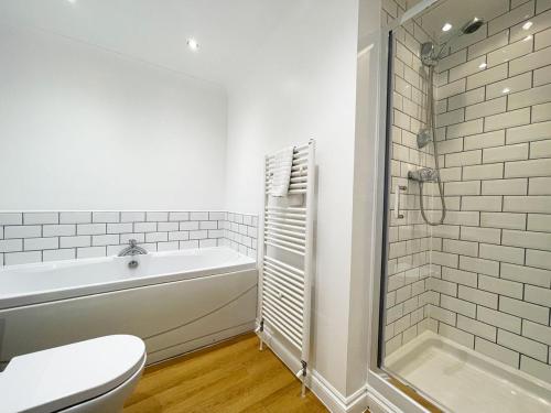 La salle de bains est pourvue d'une baignoire, de toilettes et d'une douche. dans l'établissement Chy Lowen, à Newquay
