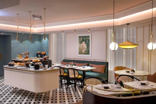 a dining room with tables and chairs and a restaurant at Maison Rouge Strasbourg Hotel & Spa, Autograph Collection in Strasbourg