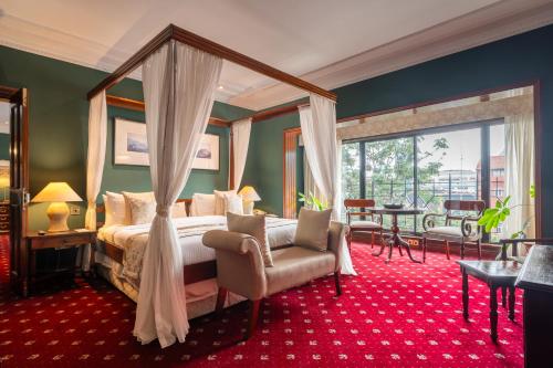內羅畢的住宿－薩洛瓦士丹利酒店，一间卧室配有一张天蓬床、椅子和一张桌子