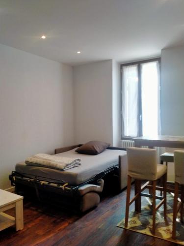 une chambre avec un lit, une table et une chaise dans l'établissement Le Grand Saint Antoine, à Saint-Jean-de-Maurienne