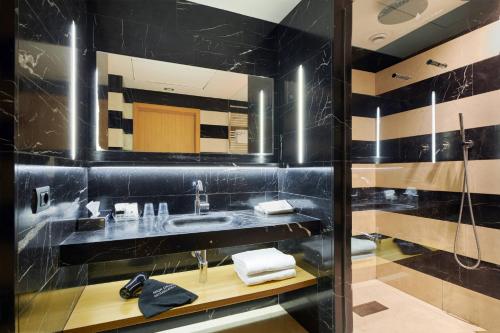 uma casa de banho preta com um lavatório e um chuveiro em Hotel Plaza em Mestre