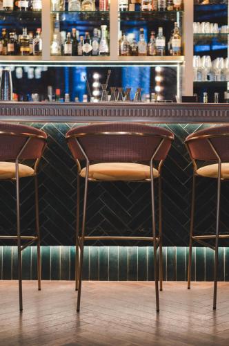 a bar with two chairs in front of a counter at Maison Rouge Strasbourg Hotel & Spa, Autograph Collection in Strasbourg