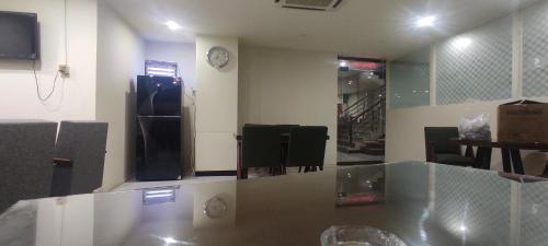 a room with a table and a clock on the wall at Hotel Daffodils in Rawalpindi