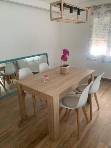 a dining room table with white chairs and a wooden table at Apartamento Avenida Principal II in Altea