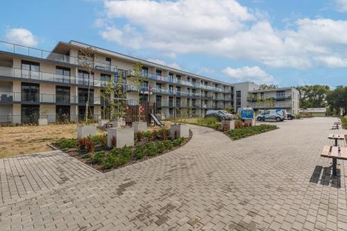 a building with a parking lot in front of it at Wellness Resort & SPA Dziwnów Apartments with Parking by Noclegi Renters in Dziwnów