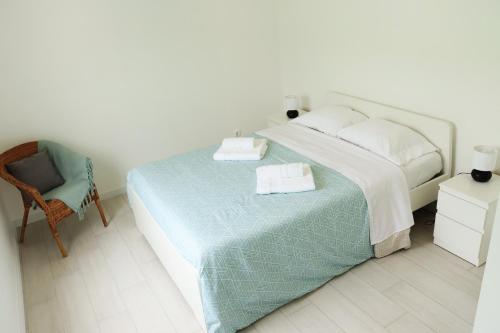 a bedroom with a large bed and a chair at Casa do Bairro in Horta