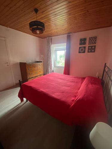 a bedroom with a red bed with a wooden ceiling at Appartamento TERESA in Rio nellʼElba