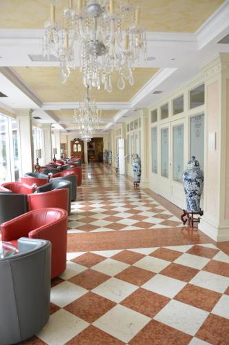 a restaurant with red chairs and a checkered floor at Grand Hotel Liberty in Riva del Garda