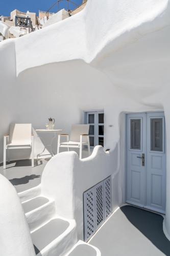 a white house with white stairs and a blue door at Vogue Suites in Oia