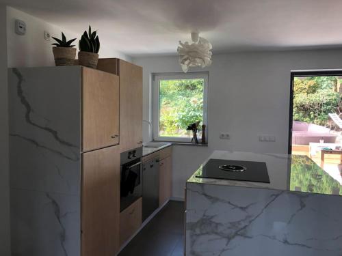 a kitchen with marble counter tops and a refrigerator at Helle große Wohnung mit grandiosem Ausblick, Terrasse und Balkon in Bühlertal