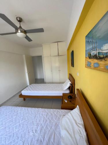 een slaapkamer met een bed en een plafondventilator bij Iris Village Grand Apartment in Paphos City