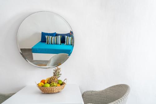 a mirror on a table with a bowl of fruit at Vogue Suites in Oia
