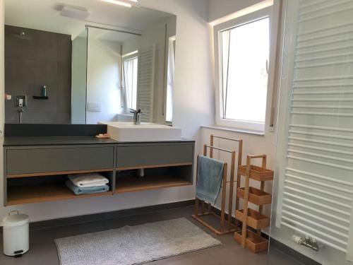 a bathroom with a sink and a mirror at Helle große Wohnung mit grandiosem Ausblick, Terrasse und Balkon in Bühlertal