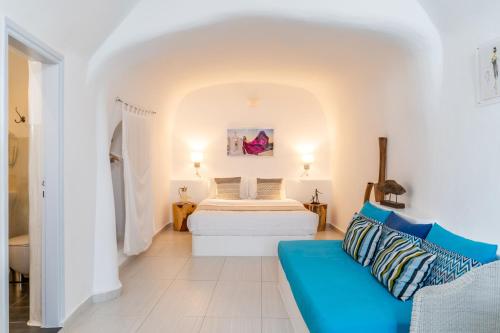 a white room with a bed and a couch at Vogue Suites in Oia