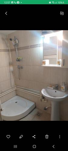 a bathroom with a sink and a tub and a toilet at Casa Ana in Eforie Sud