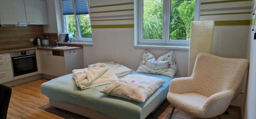 a small kitchen with a chair and a couch with pillows at Ferienwohnungen Sammer in Strobl