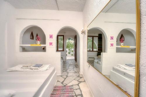a bathroom with two beds and a mirror at AKTI ARGO in Palaiokastro