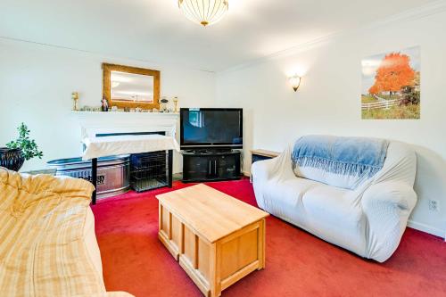a living room with a white couch and a tv at Woodsy Ballston Spa Home 4 Mi to State Park! in Ballston Spa