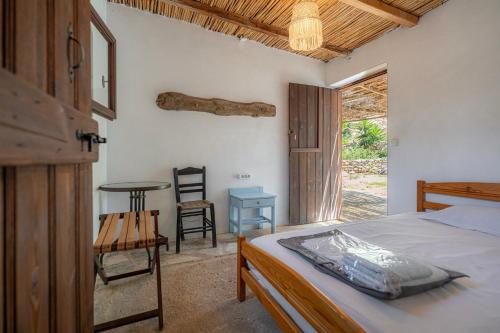 a bedroom with a bed and a table and a window at AKTI ARGO in Palaiokastro