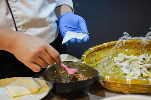 a person in blue gloves preparing food on a table at Four Points by Sheraton Changsha, Meixi Lake in Changsha
