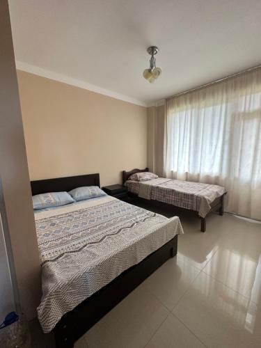 a bedroom with two beds and a window at Hotel Ureki in Ureki