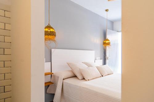 a bedroom with a white bed with two pillows at Calas De Meca in Los Caños de Meca