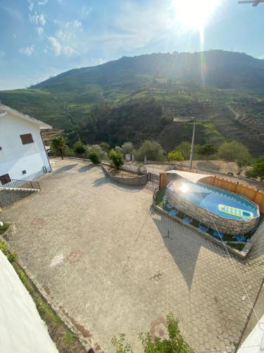a swimming pool in a yard with a view of a mountain at Casa da Amendoeira Covelinhas in Peso da Régua