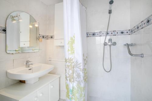 a white bathroom with a sink and a shower at Geranio in Caserío Bacarot