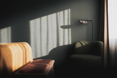 un salon avec une chaise et une lampe dans l'établissement Hotell Lappland, à Lycksele