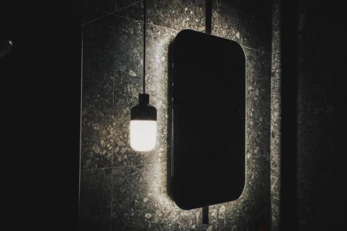 a light hanging on a wall next to a mirror at Hotell Lappland in Lycksele