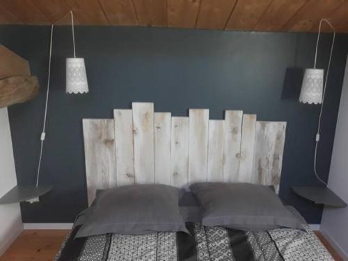 Schlafzimmer mit einem Kopfteil aus Holz und einem Bett in der Unterkunft AU MAS D'EMMA in Bourg-Saint-Andéol
