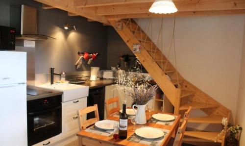 une cuisine avec une table en bois et un escalier dans l'établissement AU MAS D'EMMA, à Bourg-Saint-Andéol